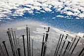 Reflexion von Himmel und Wolken in der Wasseroberfläche eines modernen Brunnens.