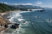 Cannon Beach with waves breaking on rocky shoreline from above, USA