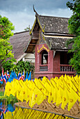 Yellow prayer flags in front of a wat temple, bright colours, Thailand