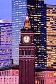 King street station clock, among tall skyscrapers in Seattle at dusk, USA