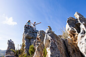 Zwei Kinder klettern auf einem Naturlehrpfad auf große Felsformationen aus Sandstein, Phillipskop Naturreservat, Südafrika