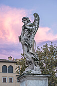 Statue of an angel with wings, dawn sky, Rome, Italy