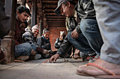 Einheimische Männer spielen ein Spiel am Tempel, Bhaktapur, Lalitpur, Kathmandu Tal, Nepal, Himalaya, Asien, UNESCO Weltkulturerbe