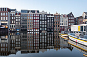 Typical Amsterdam houses with reflections in the Damrak Canal, Amsterdam, North Holland, Netherlands