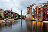 Traditionelle Wohnhäuser in Amsterdam, in der Mitte der Uhrturm Montelbaanstoren, Morgendämmerung, Amsterdam, Noord-Holland, Niederlande
