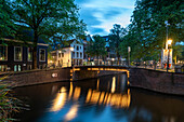 Traditionelle Wohnhäuser in Amsterdam, Brücke, Lichtspiegelung in einer Gracht, Morgendämmerung, Amsterdam, Noord-Holland, Niederlande