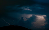 Beautiful Lightning Strikes and Clouds at Night on Mountain in Lugano, Ticino, Switzerland.