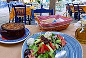 Moussaka und griechischer Salat mit Fetabällchen und schwarzer Olivenpaste, serviert in der Taverne Blue Chairs Restaurant auf der Platea von Vourliotes auf der Insel Samos in Griechenland