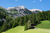 Wooden hut at the Berggasthof Hermine, behind it the 2594 meter high Zwölferspitze, European long-distance hiking trail E5, Madau, Tyrol, Austria