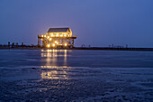 Sandy beach of St. Peter-Ording with illuminated stilt house, St. Peter-Ording, Wadden Sea National Park, Schleswig-Holstein, Germany