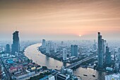 Thailand, Bangkok, Riverside Area, High Angle City Skyline von Chao Phraya River, Dämmerung.