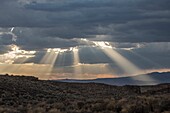 Stormy skies pass through the Southern Utah landscape and produce sunbeams at sunset.