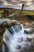 Ein Wasserfall auf dem Devonport Leat bei Windy Post im Dartmoor National Park. Eine lange Verschlusszeit wurde verwendet, um die Bewegung des Wassers zu verwischen, das an einem Nachmittag Mitte Januar über die Wasserfälle kam.