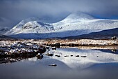 Schneebedeckte Gipfel spiegeln sich im Fluss Ba&#39; am südlichen Rand des Rannoch Moor in den schottischen Highlands.