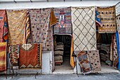 Teppiche hängen außerhalb eines Ladens, Essaouira, Marrakesch-Safi, Marokko.