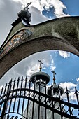 High angle view of closed iron gate with stone archway depicting Christian religious icons in front of Sabor Sviatoj Trojcy,Orthodox church,Poland.