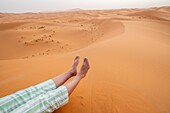 Tourist resting on the sand,Merzouga,Morocco.