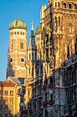 Rathaus ein Rathausgebäude und sein Glockenturm im Sonnenlicht in München, Deutschland.
