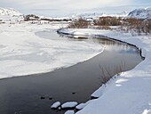 Fluss Oexara. Thingvellir Nationalpark in Island im Winter mit frischem Schnee bedeckt. Thingvellir ist Teil des UNESCO-Weltkulturerbes. Nordeuropa, Skandinavien, Island, Februar.
