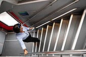 Frau, die ihr Smartphone benutzt und auf einer Treppe in einem First-Class-Zug in der Schweiz hinaufgeht.