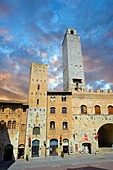 Die Piazza Duomo (Domplatz) von San Gimignano mit ihren mittelalterlichen Türmen, die als Verteidigungstürme gebaut wurden, aber auch, um den Reichtum der Familie durch die Höhe der Türme zu zeigen. Eine UNESCO-Weltkulturerbestätte. San Gimignano; Toskana Italien.