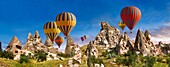 Hot air balloons over the cave city houses in the rock formations & fairy chimney of Uchisar,Cappadocia,Turkey