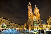 Krakau, Polen am 23. September 2018: Der größte mittelalterliche europäische Stadtplatz bei Nacht - der Marktplatz in Krakau mit der gotischen Marienkirche, Polen.