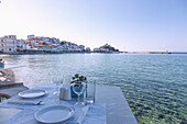 Kokkari, Altstadt mit Tavernen und gedecktem Tisch am Hafen auf der Insel Samos in Griechenland