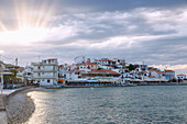Kokkari, distinctive clouds and sunbeams of the old town on the island of Samos in Greece