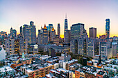 Manhattan, New York, USA. Lichter in den Fenstern von Wolkenkratzern bei Sonnenuntergang.