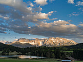 The Karwendel Mountain Range near Mittenwald during spring, lake Wagenbruch (also called Geroldsee). Sunset over the lake with the still snow covered peaks of the western Karwendel mountains towering above Mittenwald in the background. Bavaria