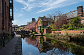 Der Castlefield Canal mit Schleusenwärterhaus spiegelt sich im Frühjahr wider, Manchester, England, Vereinigtes Königreich, Europa