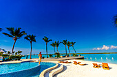 Frau mit Blick auf das Meer vom Pool im Blue Haven Resort, Providenciales, Turks- und Caicosinseln, Atlantik, Mittelamerika