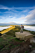 Ein Wanderer, der während einer Wolkeninversion über den Great Ridge blickt, mit Blick auf Mam Tor, Hope Valley, Peak District, Derbyshire, England, Vereinigtes Königreich, Europa
