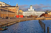 Der historische überdachte Markt Vanha Kauppahalli aus dem 19. Jahrhundert am Hafen mit der Fassade des Rathauses und der grünen Kuppel des Glockenturms der lutherischen Kathedrale von Helsinki, Finnland, Europa