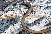 Türkei, Kappadokien, Luftaufnahme der kurvenreichen Straße in felsiger Landschaft im Winter