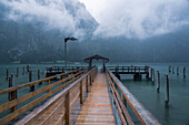 Germany, Bavaria, Pier on Koenigsee and cloud covered mountains