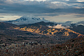 Bolivien, La Paz, Stadt umgeben von schneebedeckten Bergen und Wolken