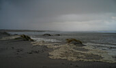 Storm clouds above sandy beach and sea