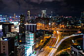 Blick auf das Stadtbild mit Verkehr auf der Straße bei Nacht, Hongkong