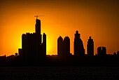 Silhouette of high rise buildings against sky at sunset