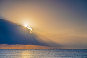 USA, Florida, Boca Raton, Sun rising behind clouds above sea