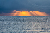 USA, Florida, Boca Raton, Sunbeams behind clouds above sea at sunrise