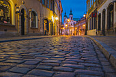 Polen, Masowien, Warschau, Reihenhäuser entlang der Straße mit Kopfsteinpflaster in der Altstadt bei Nacht
