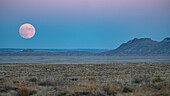 USA, New Mexico, Shiprock, Full moon rising over Navajo Nation desert landscape