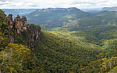 Australia, New South Wales, Three Sisters rock formation with Mount Solitary and Jamison Valley in Blue Mountains National Park seen from Echo Point Lookout