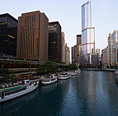 Usa, Illinois, Chicago, Downtown buildings and boats moored by river at dawn