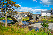 Blick auf Pont Fawr (Inigo Jones Bridge) über Conwy River und Riverside Häuser, Llanrwst, Clwyd, Snowdonia, North Wales, Vereinigtes Königreich, Europa