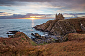 Ruinen von Dunskey Castle an der zerklüfteten Küste bei Sonnenuntergang, Portpatrick, Dumfries and Galloway, Schottland, Vereinigtes Königreich, Europa