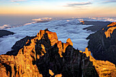 Wolken rund um den felsigen Gipfel des Pico das Torres beleuchtet von Sonnenuntergang, Insel Madeira, Portugal, Atlantik, Europa